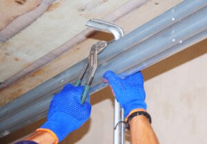 Why is my garage door jammed? Image of hands checking garage opener mechanism.