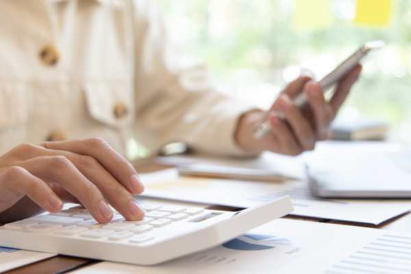 Man using calculator - Will homeowners insurance cover the cost of garage door replacement?